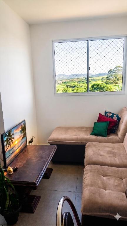 a living room with a couch and a table at Apartamento Compacto Localização Privilegiada in Uberaba