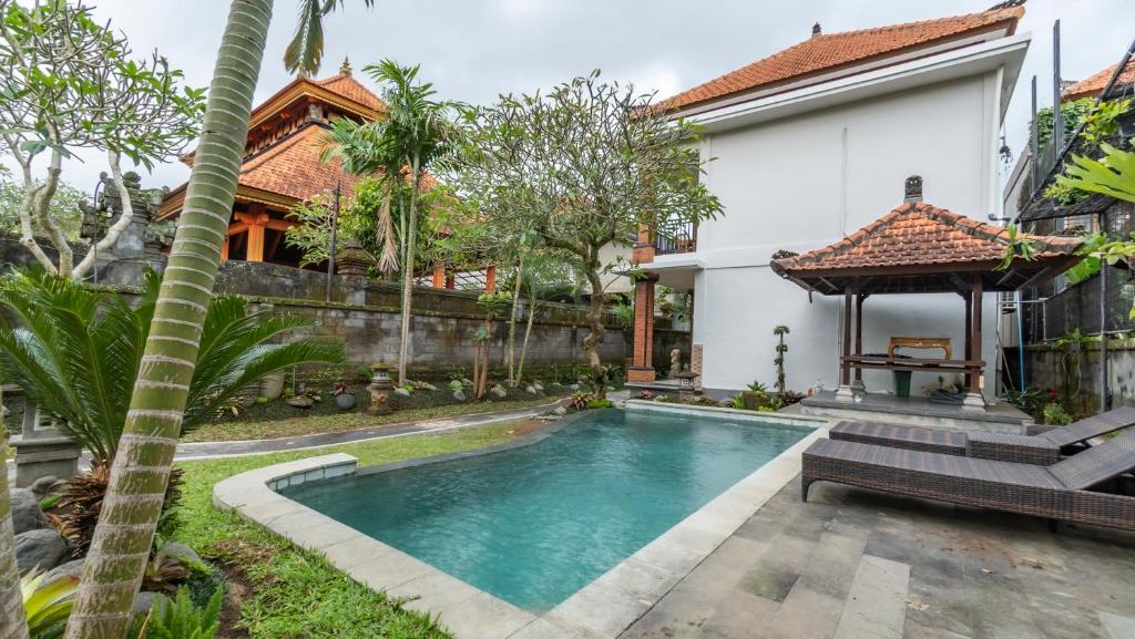 a villa with a swimming pool and a house at Sriwedari 40 Ubud in Ubud
