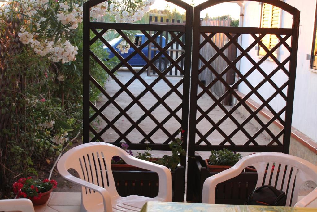 Lido SignorinoにあるCasetta a Mare Marsalaのパティオ(椅子2脚、テーブル、フェンス付)
