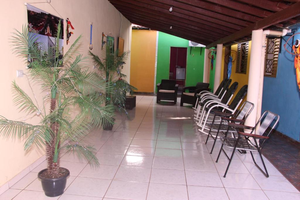 einen Flur mit Stühlen und Pflanzen in einem Gebäude in der Unterkunft Pousada Familiar Encanto da Chapada in Carolina