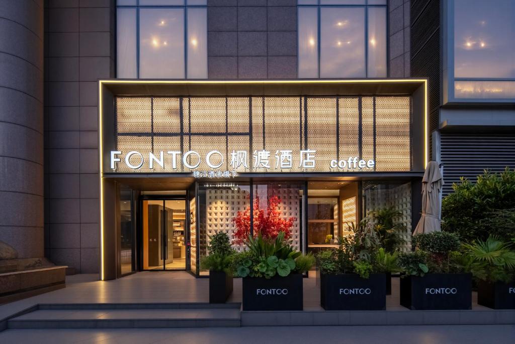 a front entrance of a building with plants in front at 枫渡酒店上海陆家嘴世纪大道地铁站店 in Shanghai