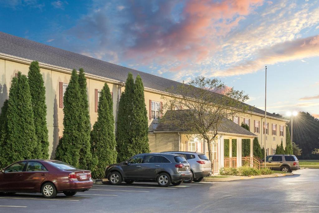 two cars parked in a parking lot in front of a building at Super 8 by Wyndham Maumee Perrysburg Toledo Area in Maumee