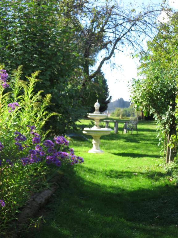 einen Park mit einem Brunnen im Gras mit Blumen in der Unterkunft Paradiesli am Hochrhein in Rheinfelden