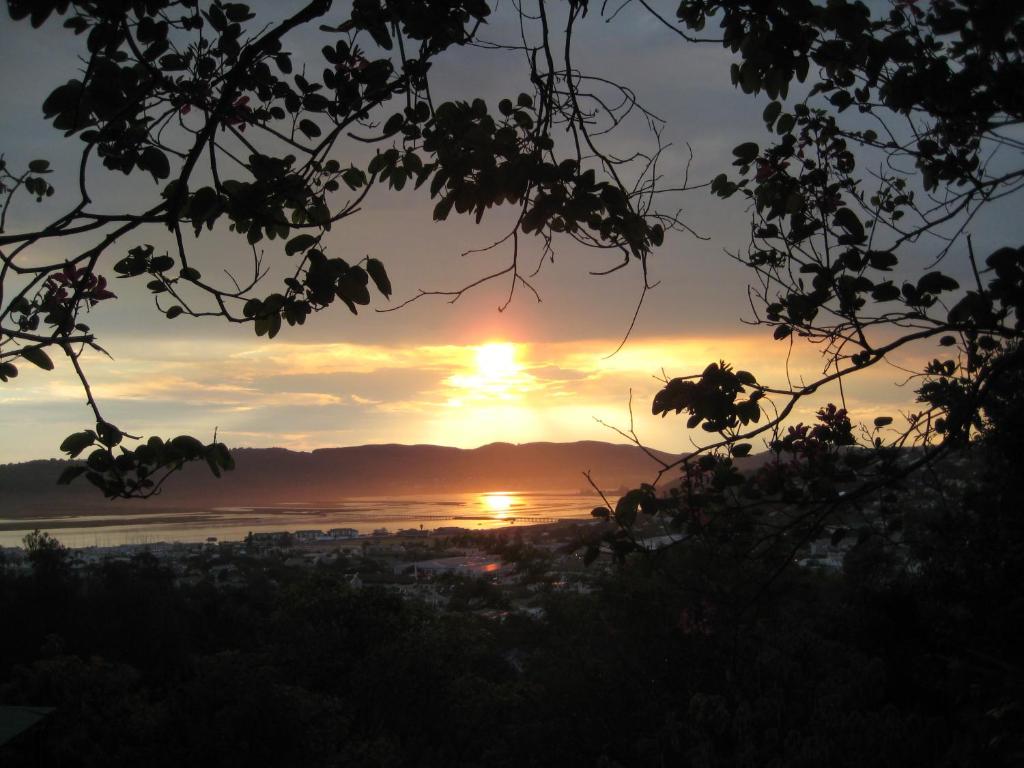 a sunset with the sun setting over the water at Mount Joy Cottages in Knysna