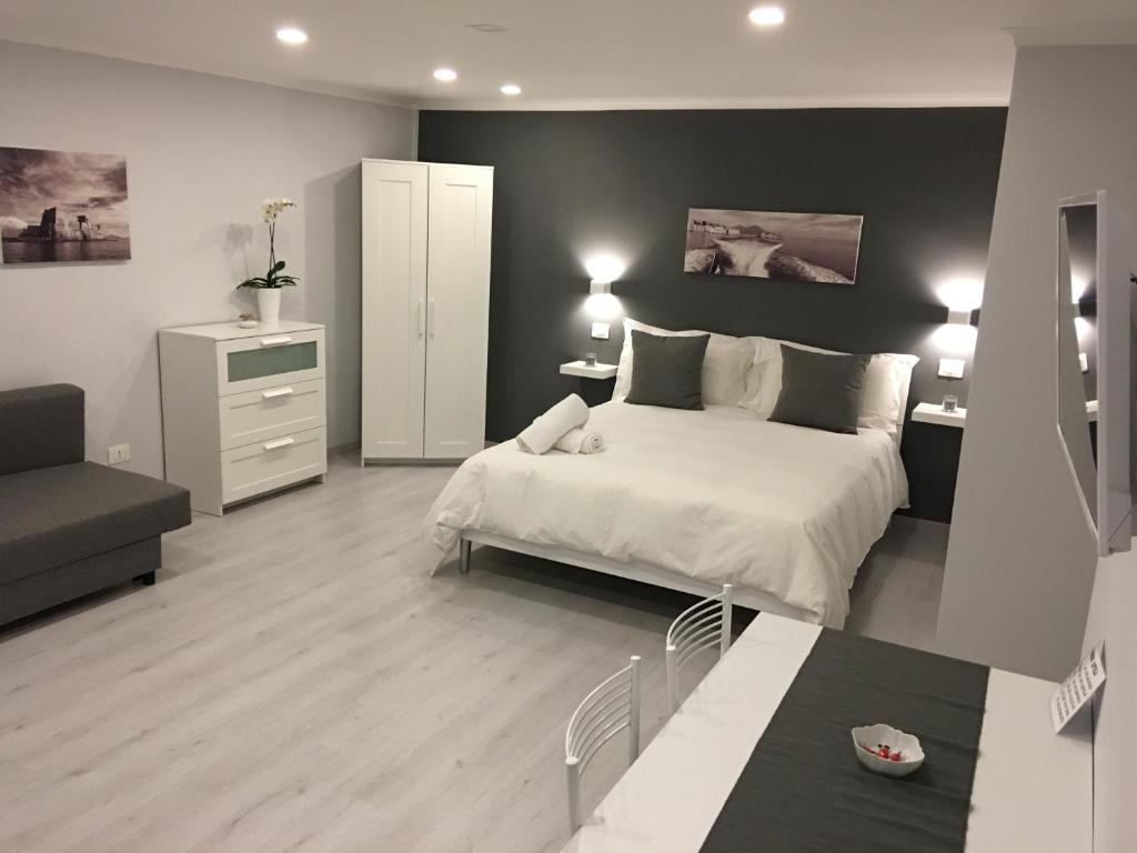ナポリにあるThe Lux B&B Napoli Mergellinaのベッドルーム1室(ベッド1台付)、リビングルームが備わります。