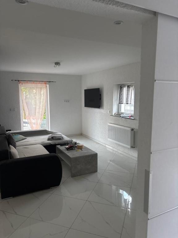 a white living room with a couch and a table at Ferienhaus Nine in Oberthal