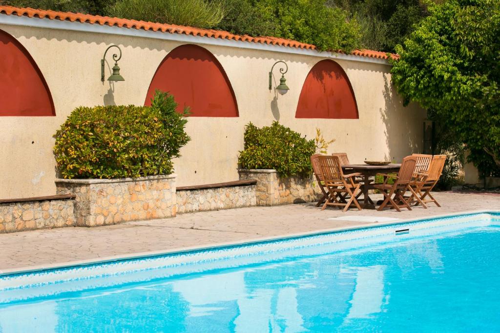 a patio with a table and chairs next to a pool at Irena Studios & Apartments in Sarlata