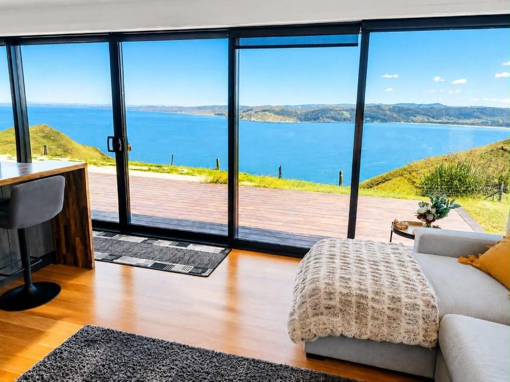 a living room with a view of the water at Ocean Waters in Mahia
