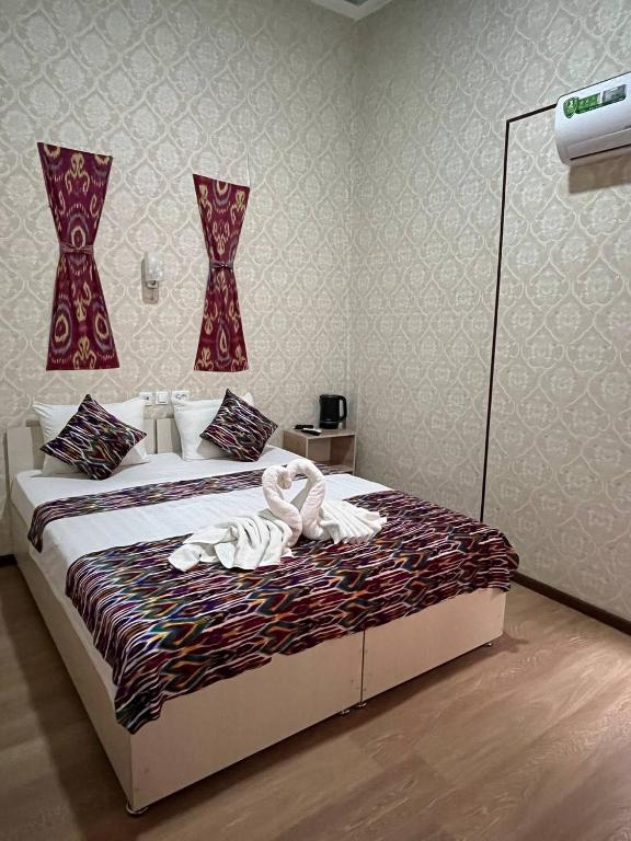 a bedroom with a bed with towels on it at Polvon Ota Hotel in Khiva