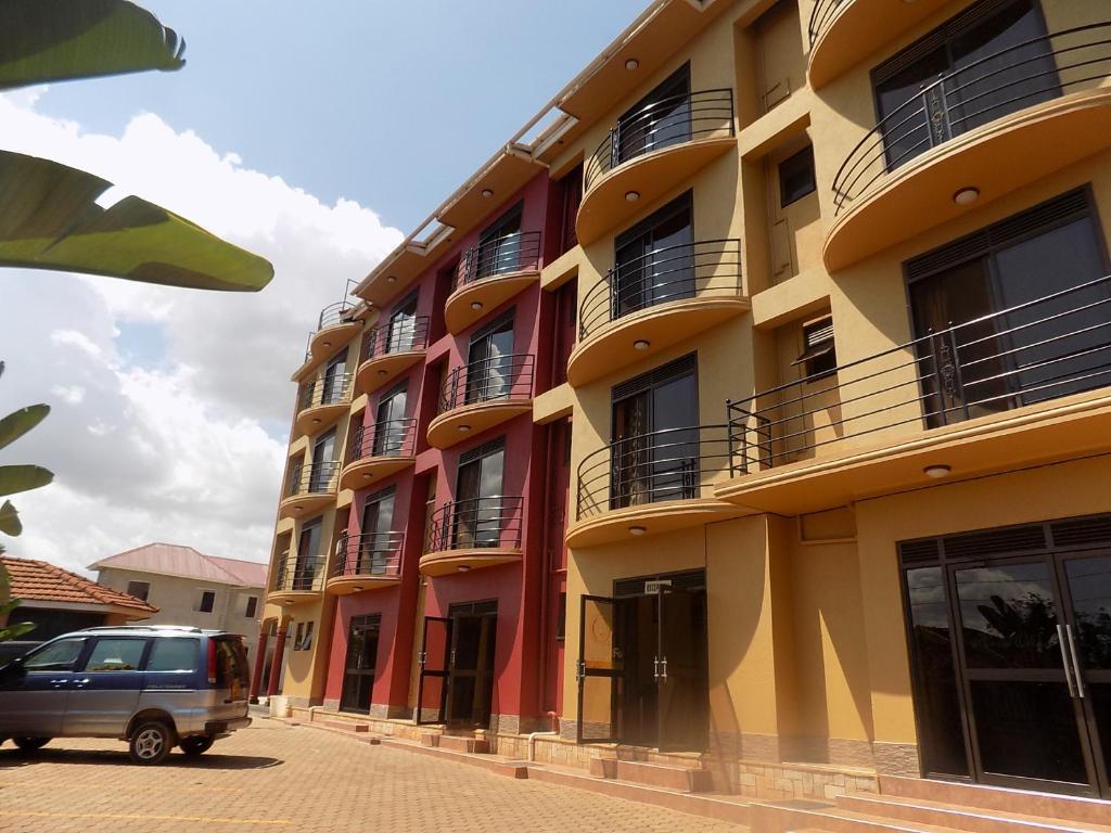 una furgoneta estacionada frente a un edificio en Olina Hotel and Apartments Kampala, en Kampala