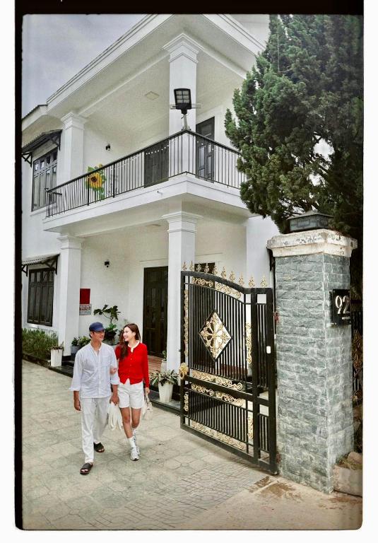 a man and woman walking in front of a house at LaLa Villa Đà Lạt in Da Lat