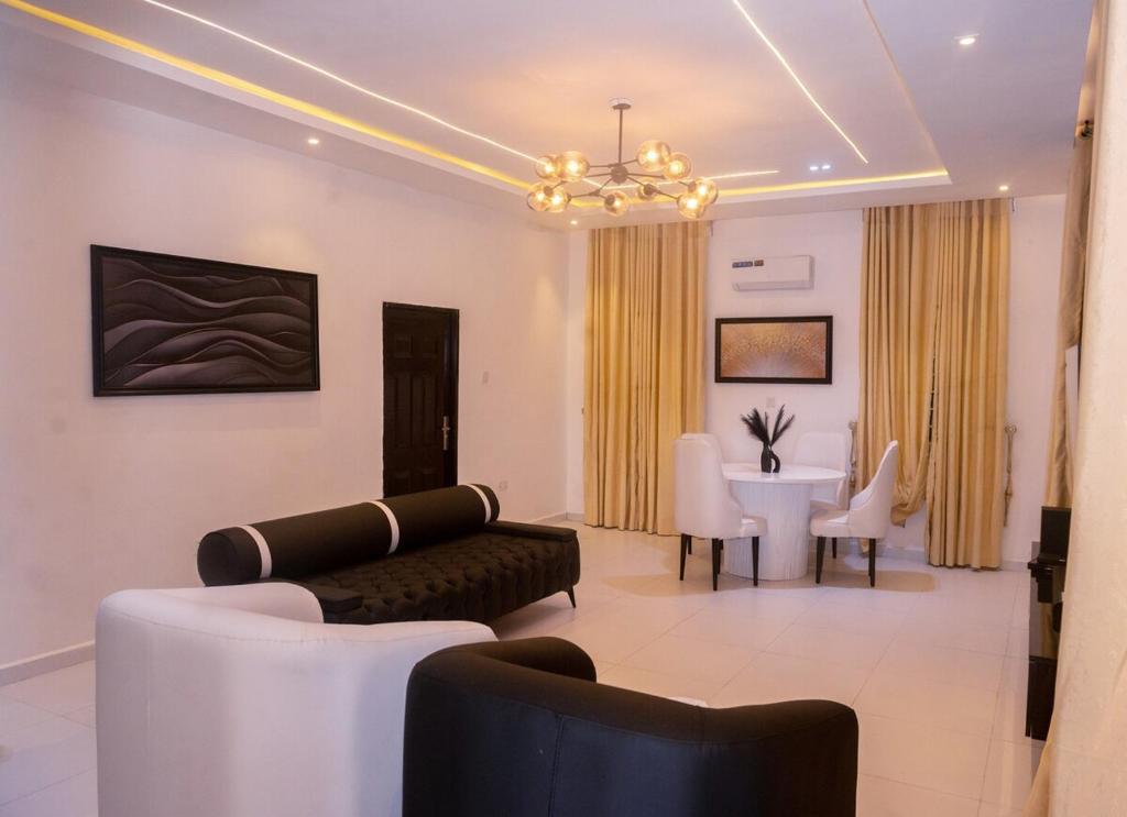 a living room with a couch and a dining room at Aulein Apartments in Abuja