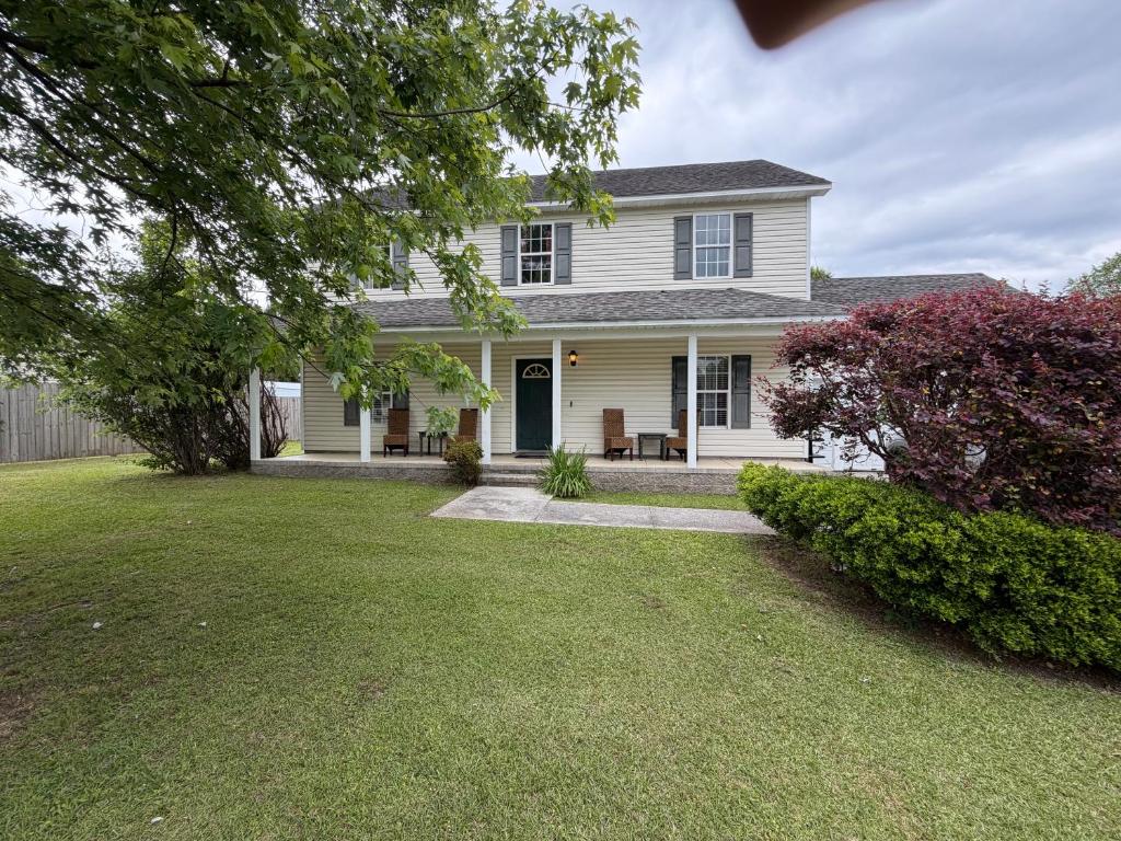 a white house with a porch and a yard at Marvielous Stay in Jacksonville