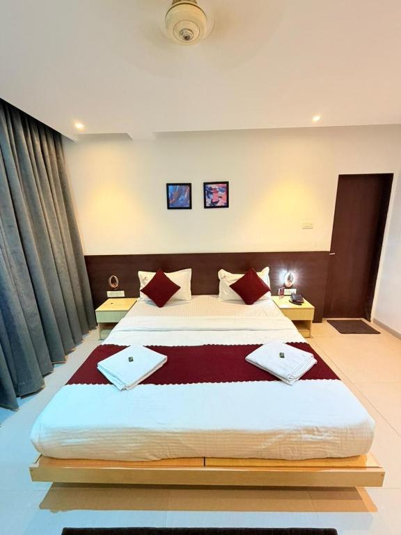 a bedroom with a large bed with red pillows at The Berry House in Satara