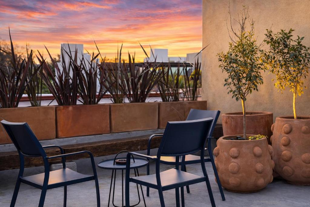 a patio with chairs and a table and a painting at Casa UMA in San Miguel de Allende