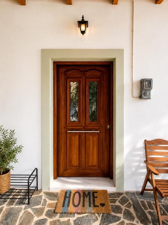a welcome mat in front of a wooden door at Small Villa Gerani in Agios Vlasios