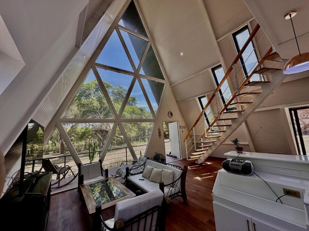 a living room with large windows and a couch at A Frame house Perú in Lambayeque