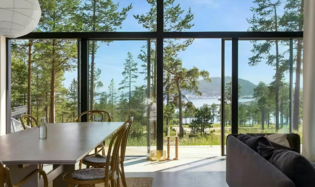 a dining room with a table and a large window at Architect Villa By Cliff Bathing In High Coast in Härnösand