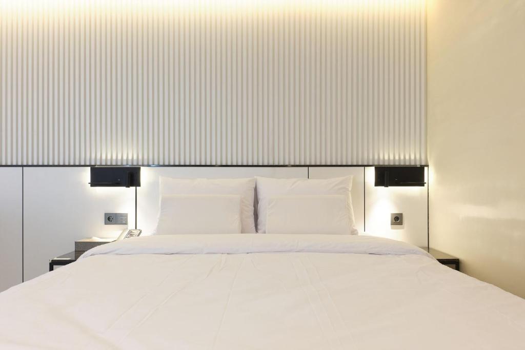 a bedroom with a white bed with white pillows at Seocho JS Hotel in Seoul