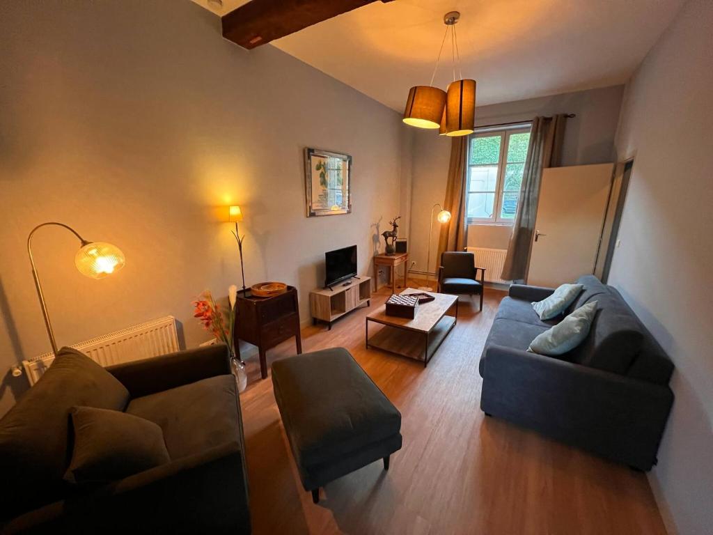 a living room with a couch and a table at 32-La Place To Be in Senlis