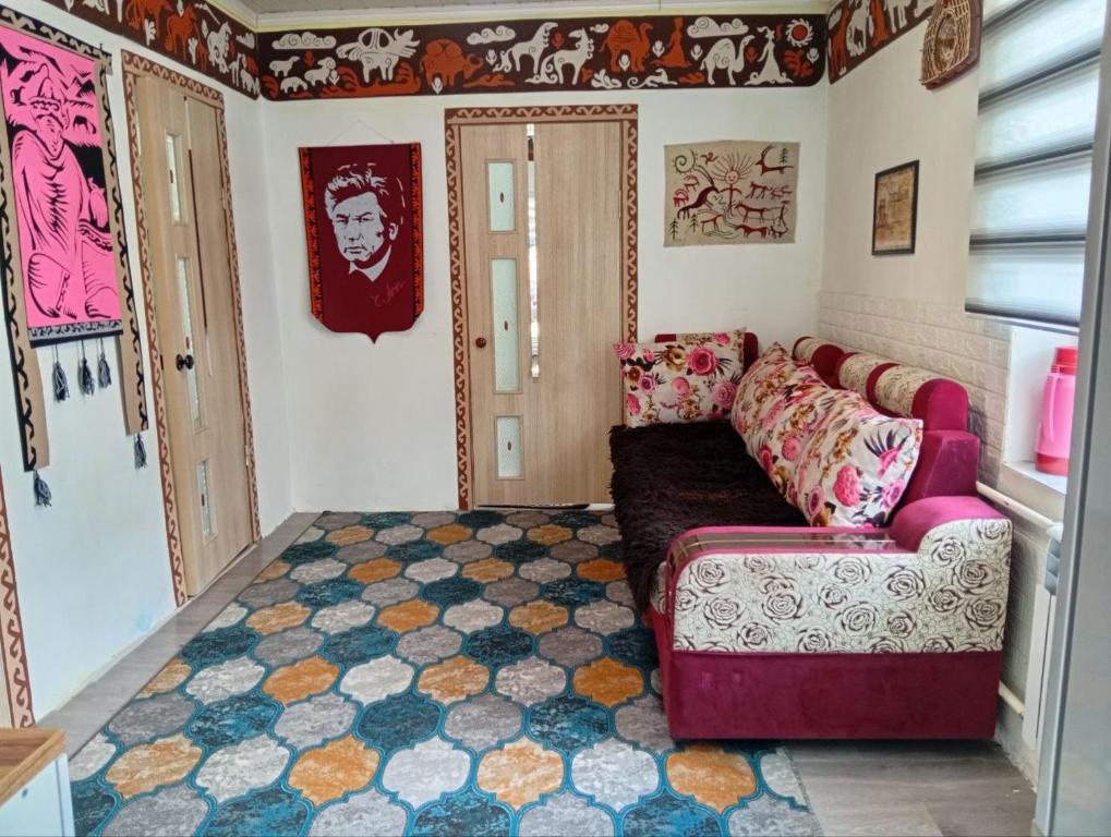 a living room with a couch and a rug at Guest House Aruuke in Naryn