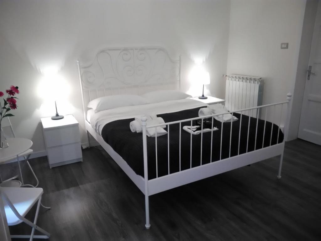 una camera da letto con un letto bianco con due tavoli e due lampade di B&B del Toscano a Catania