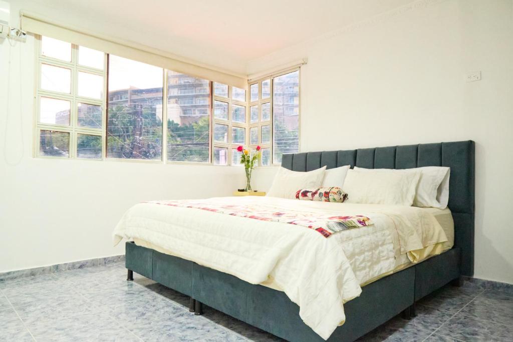 ein Schlafzimmer mit einem großen Bett und einem großen Fenster in der Unterkunft Hotel plata inn in Villavicencio