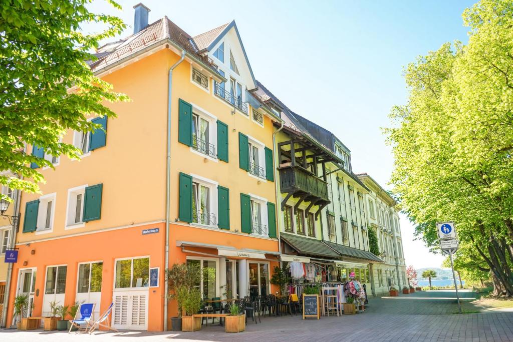 a yellow and orange building on a street at SEEMOMENTE Überlingen Promenade in Überlingen