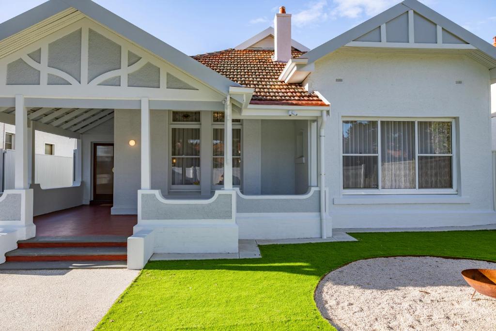 a house with a green lawn in front of it at Belle Escapes Henley's Coastal Charm in Henley Beach South