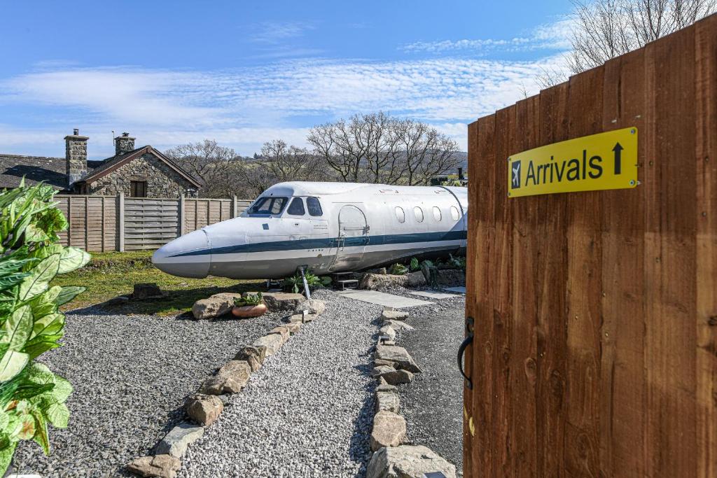a plane parked in a yard next to a house at Alaya Airways in Dolgellau
