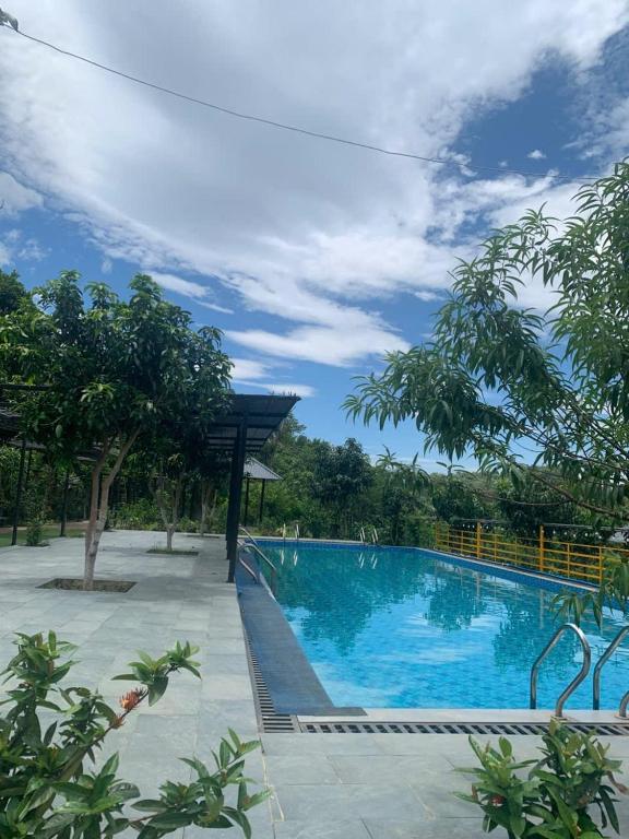 a large blue swimming pool with trees in the background at Educational Eco Ba Vi in Thủ Pháp