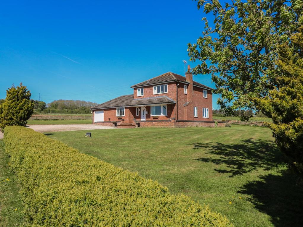a large brick house on a grassy field at Tixall Manor Farm in Stafford
