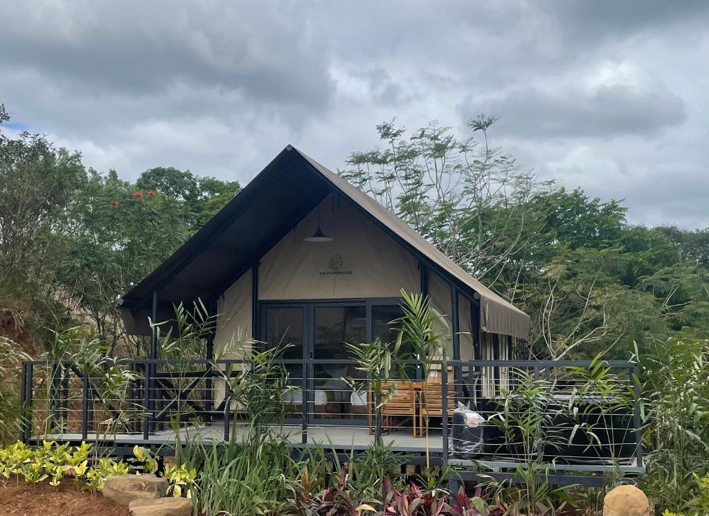 a small house with a black roof at The Playground in Baras