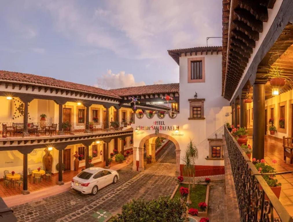 a white car parked in a courtyard of a building at Hotel Posada San Rafael in Pátzcuaro