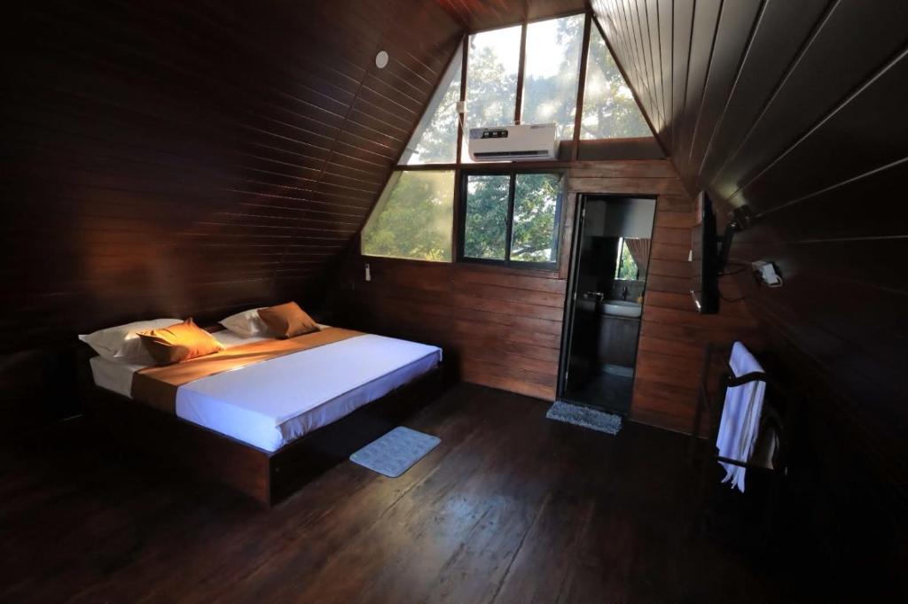a bedroom with a bed in a room with windows at Green Breeze Villa in Katugastota