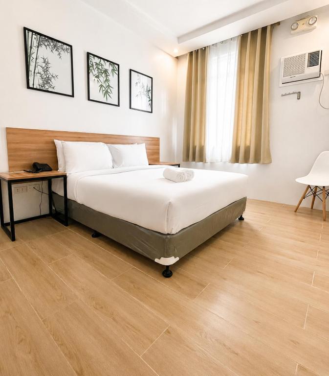 a bedroom with a bed and a table and a window at Bambu Suites in Puerto Princesa City