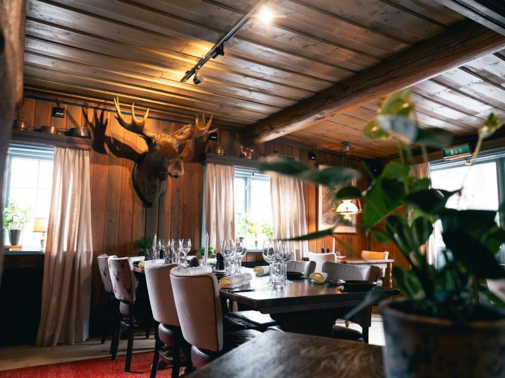 a dining room with a table and a deer head on the wall at Gammelgården in  Högfjället