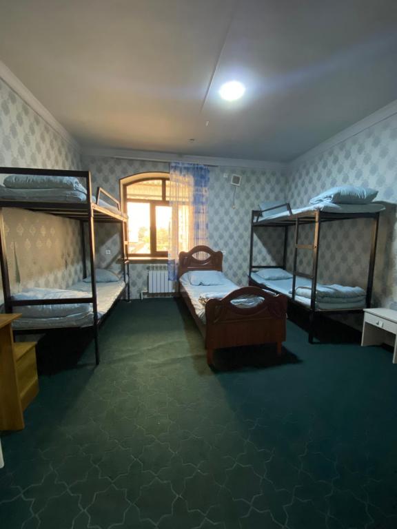 a room with two bunk beds and a window at Hostel Inn in Andijan