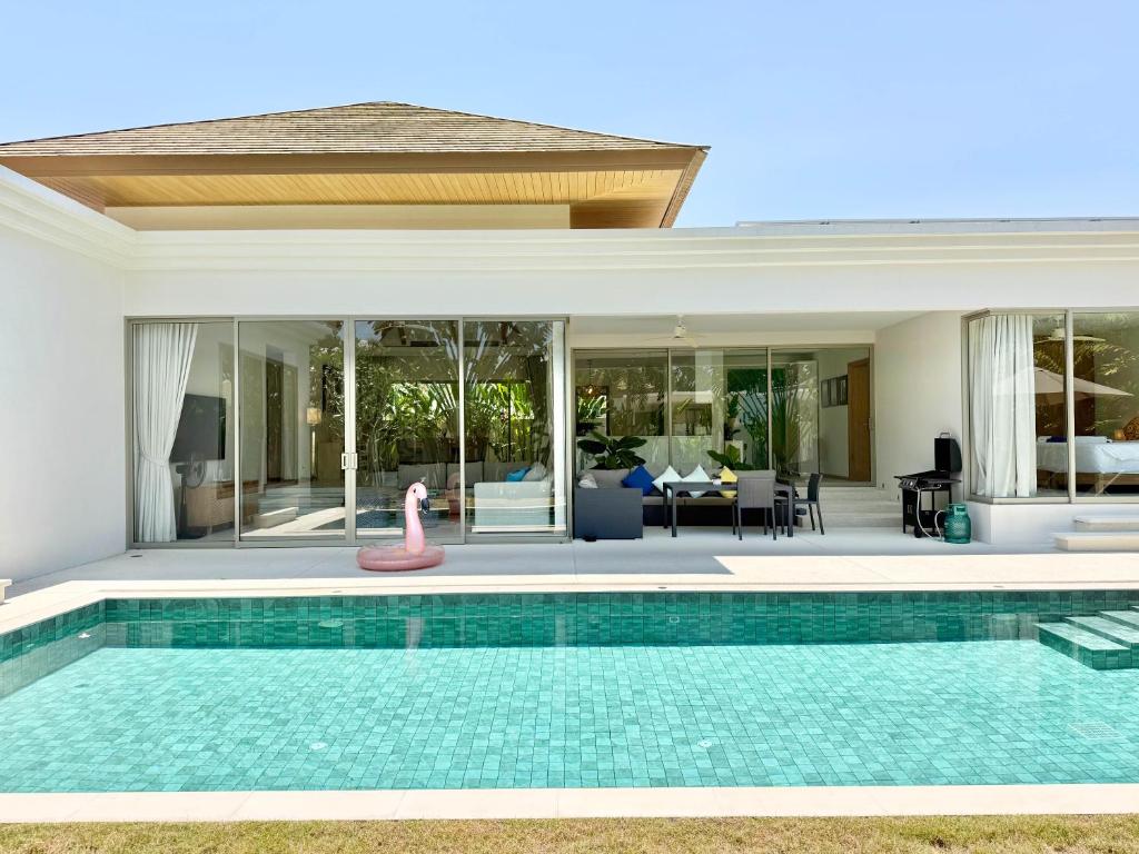 a swimming pool with a toy flamingo in a house at Bali-Style 4 BR Private Pool Villa - Trichada in Phuket