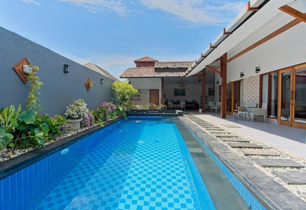 a swimming pool in the backyard of a house at KyGunAya Villa in Gili Islands