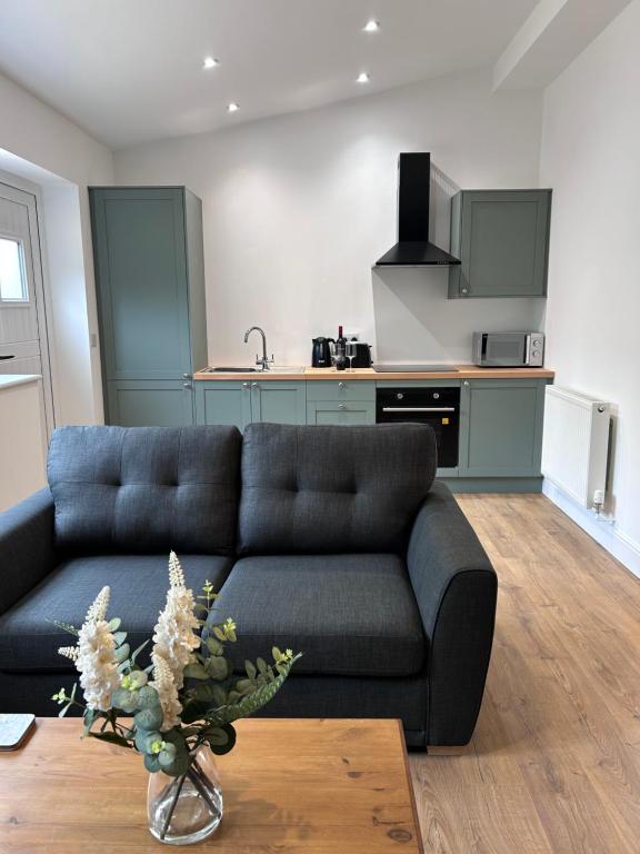 a living room with a couch and a kitchen at Sycamore Stay in Spalding