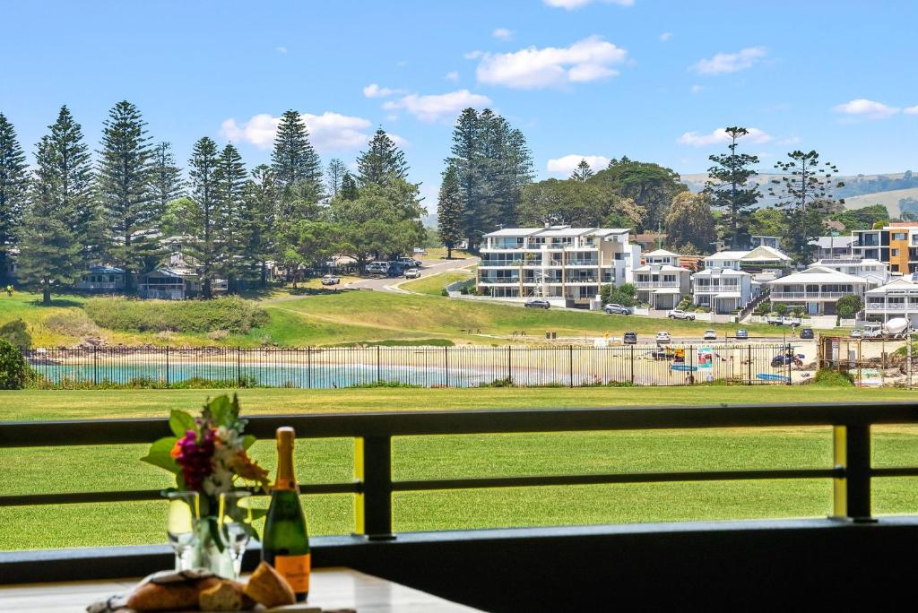 a table with a view of a park and buildings at Kove Apartment - B02 in Kiama