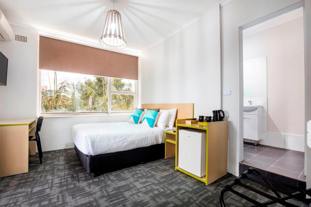 a hotel room with a bed and a window at Nightcap at Caringbah Hotel in Caringbah