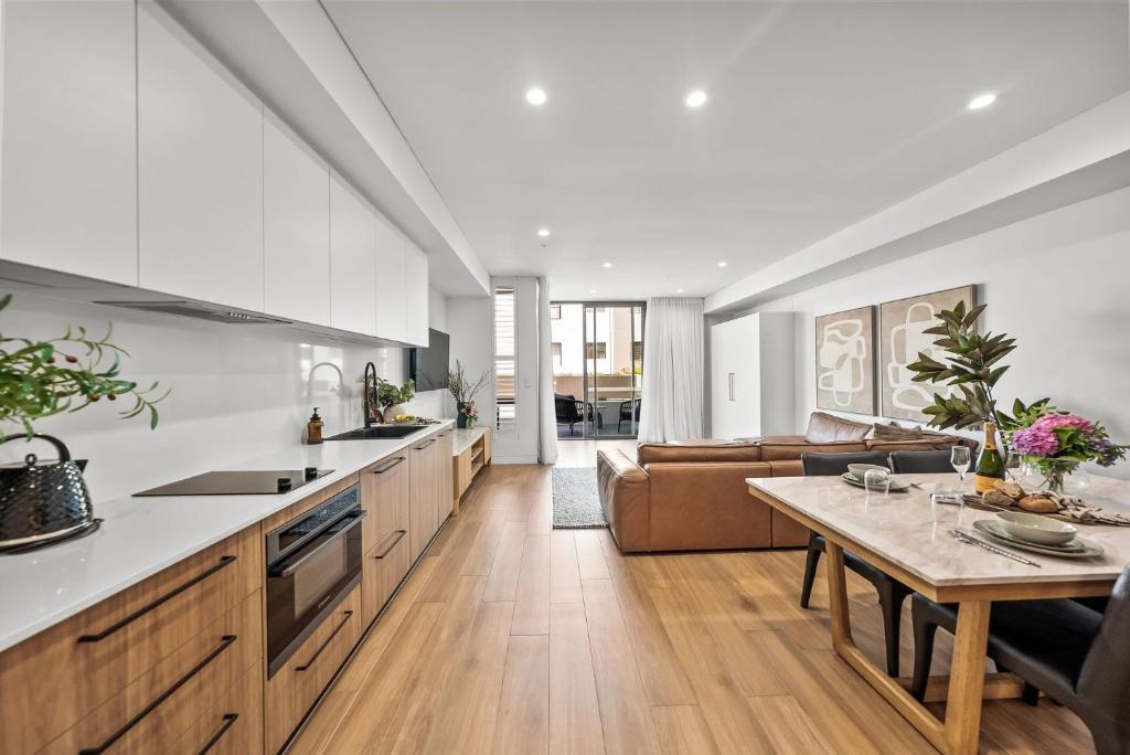 a kitchen and living room with a table and a couch at Kove Apartment - G01 in Kiama