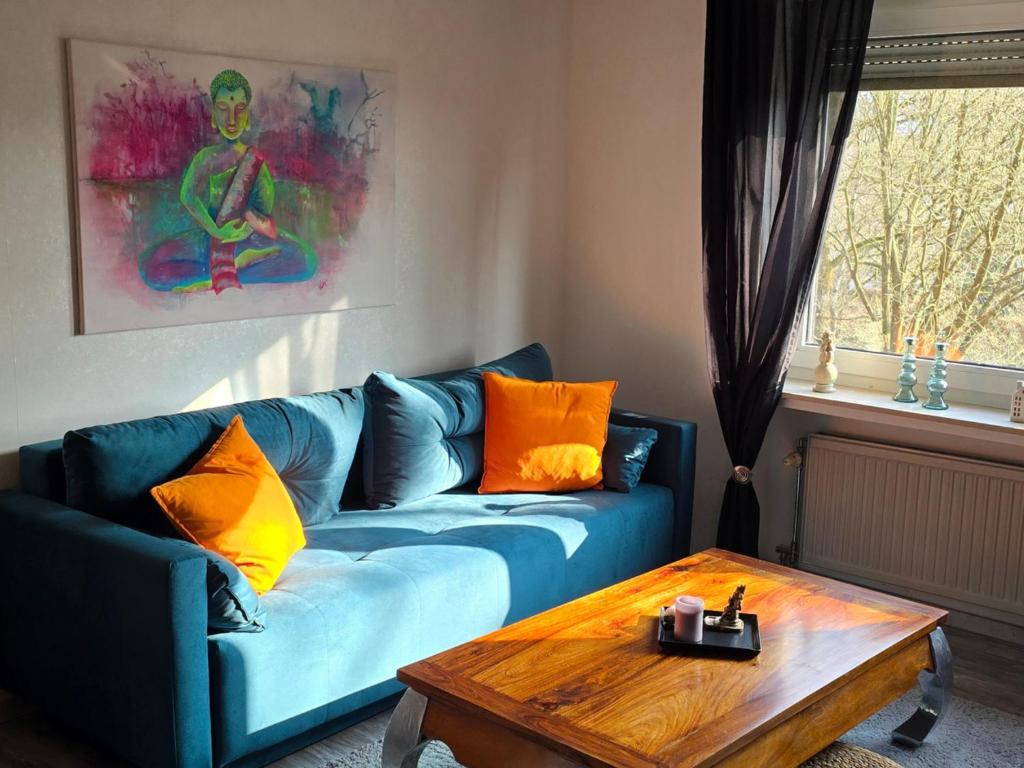 a living room with a blue couch and a wooden table at Märchenwerkstatt in Netphen