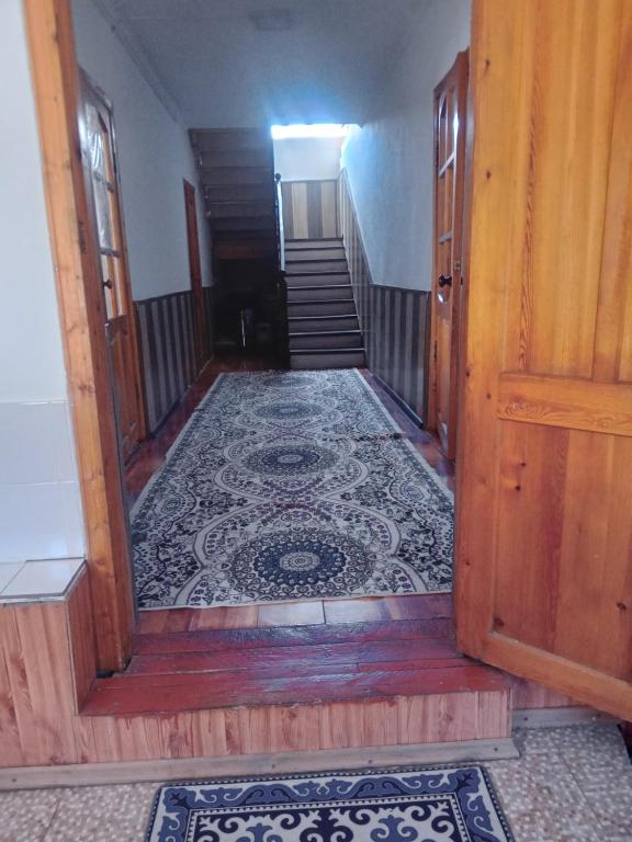 a hallway with a staircase with a tile floor at Тумар дом in Tamga