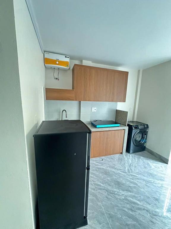 a kitchen with a black refrigerator and a stove at Nhà trọ bùi Thị lài in Dong Hoi