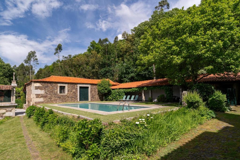a house with a swimming pool in the yard at Eira Country House in Ponte de Lima