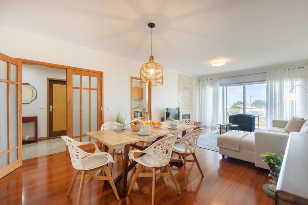 a dining room and living room with a table and chairs at São Félix Seaside Oasis in São Félix da Marinha