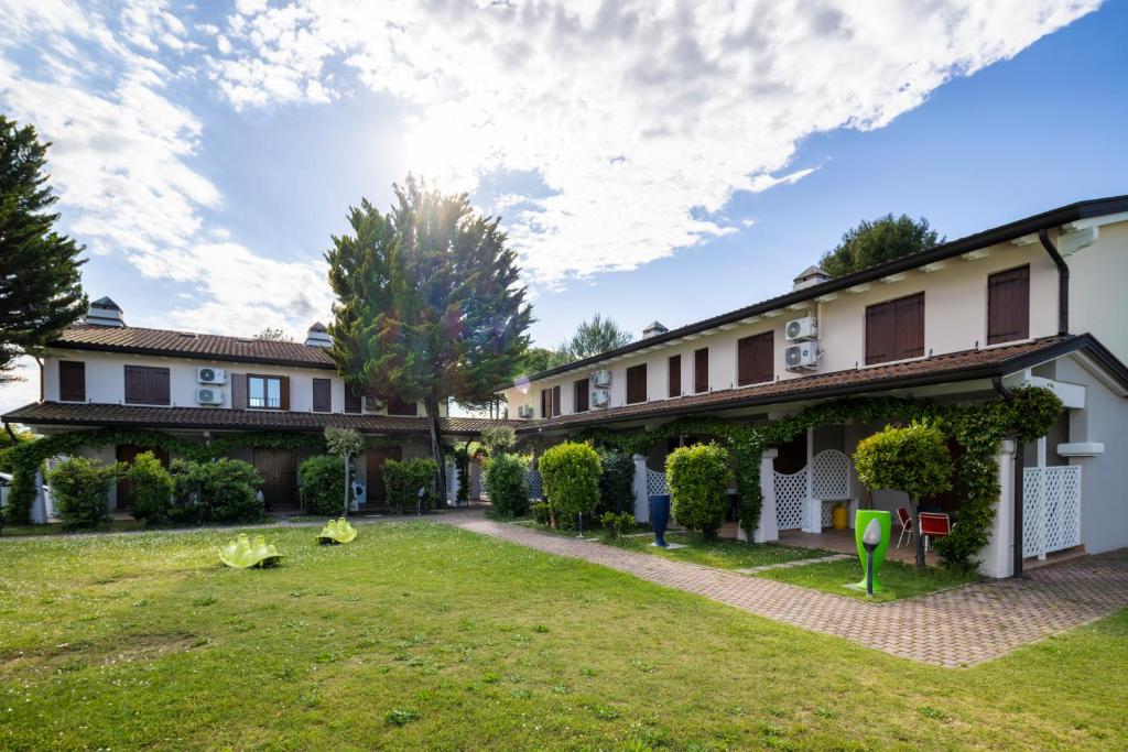 an exterior view of a house with a yard at Residence Borgo Stella Marina in Bibione